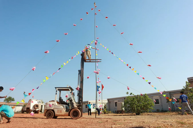 Với chiều cao khoảng 10 mét, thân cây được làm từ cây ăng-ten cũ, xung quanh là các dây cờ đủ màu sắc và chùm dây trang trí tái chế từ nilon